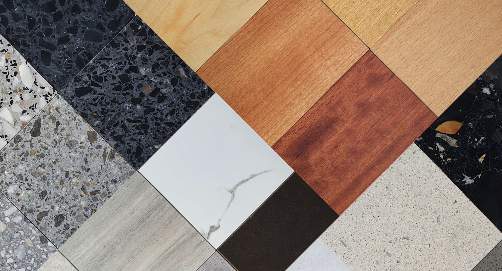 Assorted square tiles arranged in a diagonal mosaic, showing wood, stone, white, black, and speckled textures.