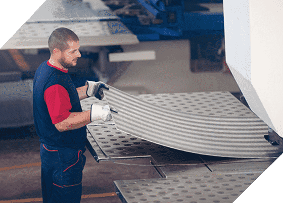 A Man is Working on a Piece of Metal in a Factory — Top End Steel Supplies Darwin In Pinelands, NT
