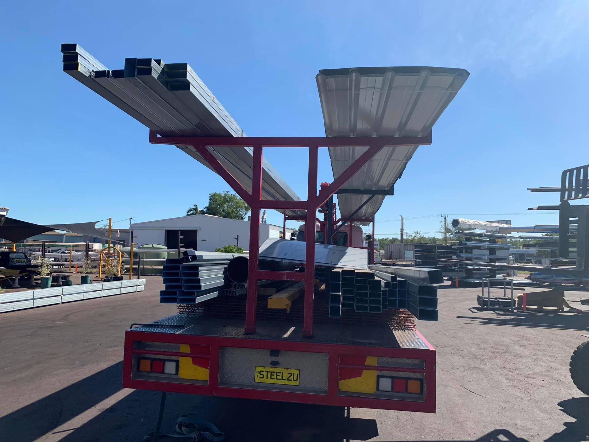 A Red Truck Carrying Steels — Top End Steel Supplies Darwin In Jabiru, NT