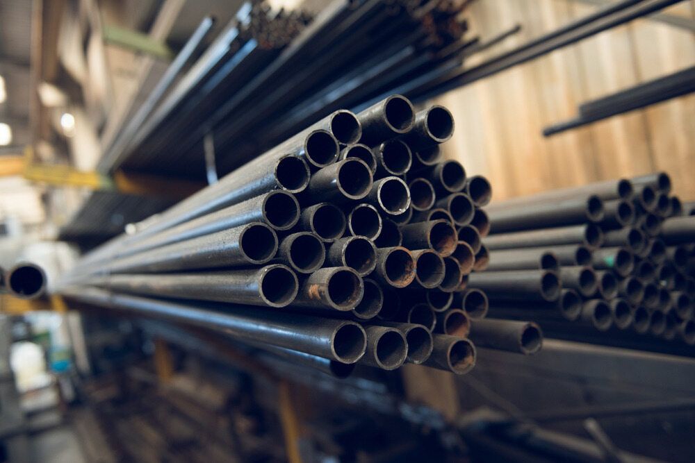 A Bunch of Metal Pipes Stacked on Top of Each Other in a Warehouse — Top End Steel Supplies Darwin In Jabiru, NT
