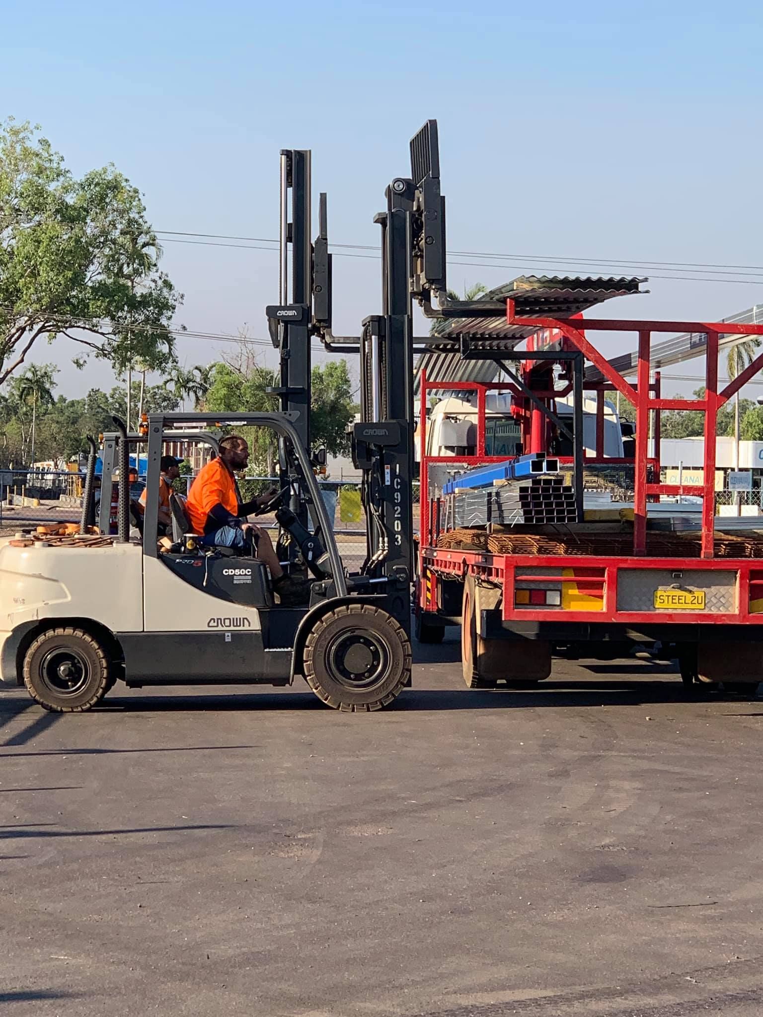 Two men are driving work buggies next to a truck — Top End Steel Supplies Darwin In Pinelands, NT