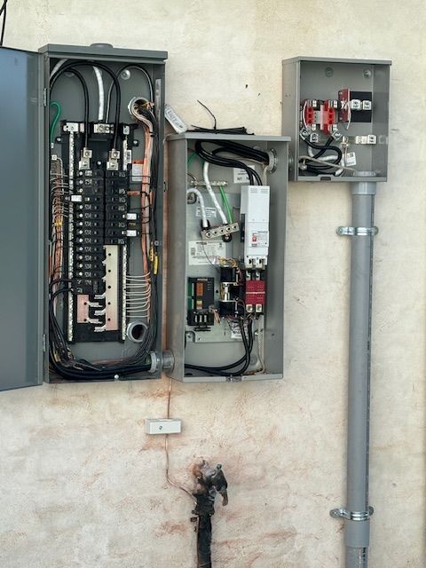 Two electrical boxes on a wall with one being open