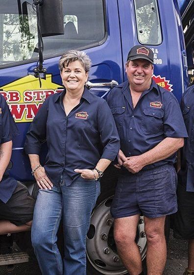 A group of people standing in front of a blue truck.