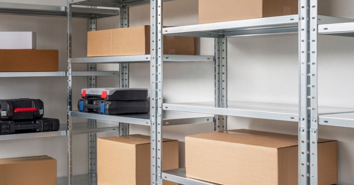 A metal shelving unit holding cardboard boxes and plastic toolboxes against a plain white background.