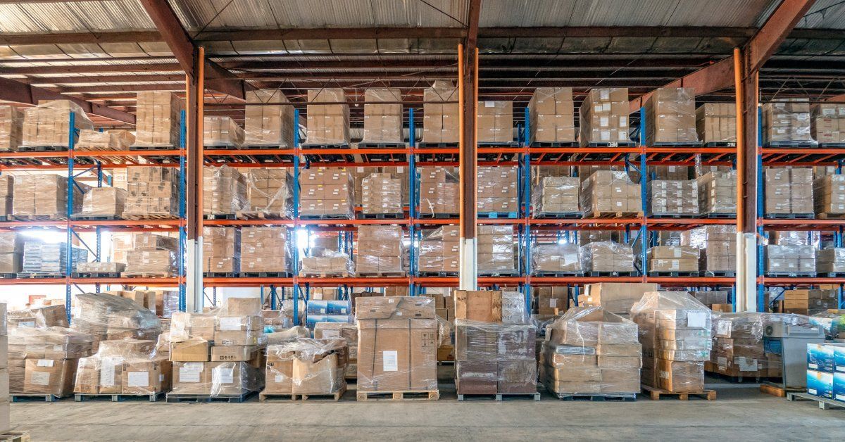 A side view of a long industrial pallet rack in a warehouse—the storage system is filled with boxes ready for transport.