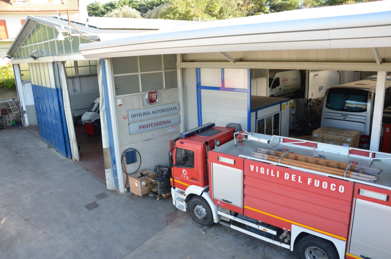 Camion dei pompieri parcheggiato fuori da una stazione dei pompieri, con la scritta