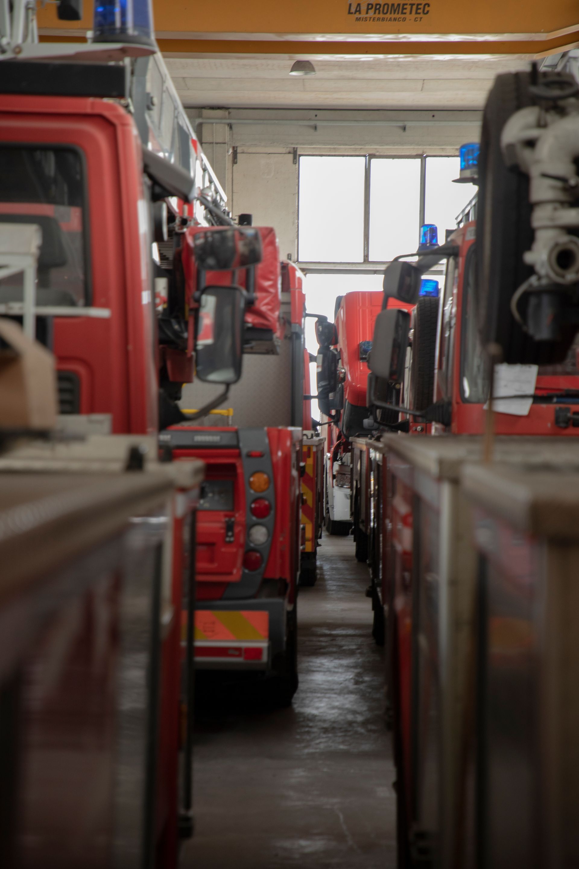 Camion dei pompieri rossi allineati all'interno di una stazione dei pompieri.
