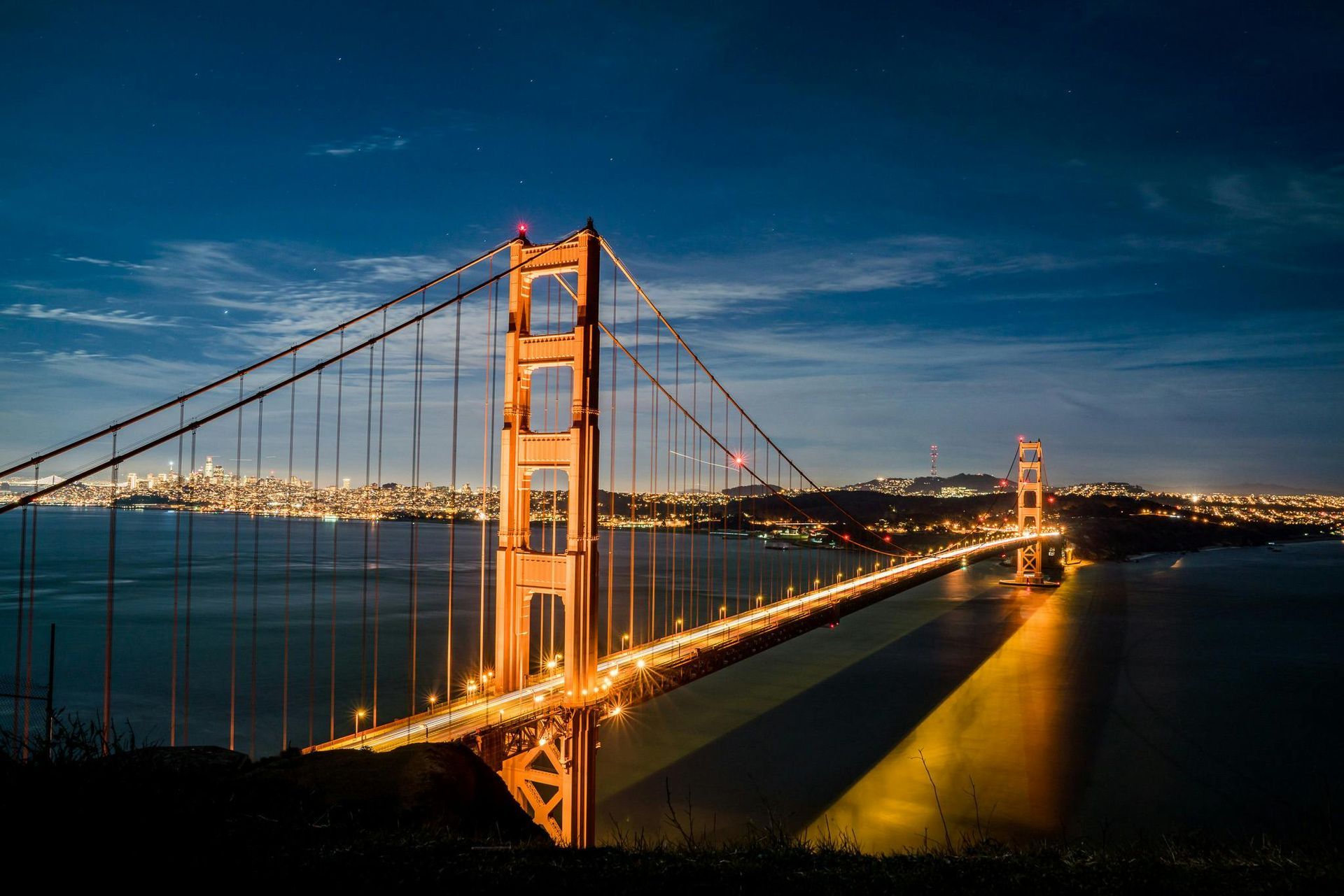 The golden gate bridge is lit up at night in san francisco.