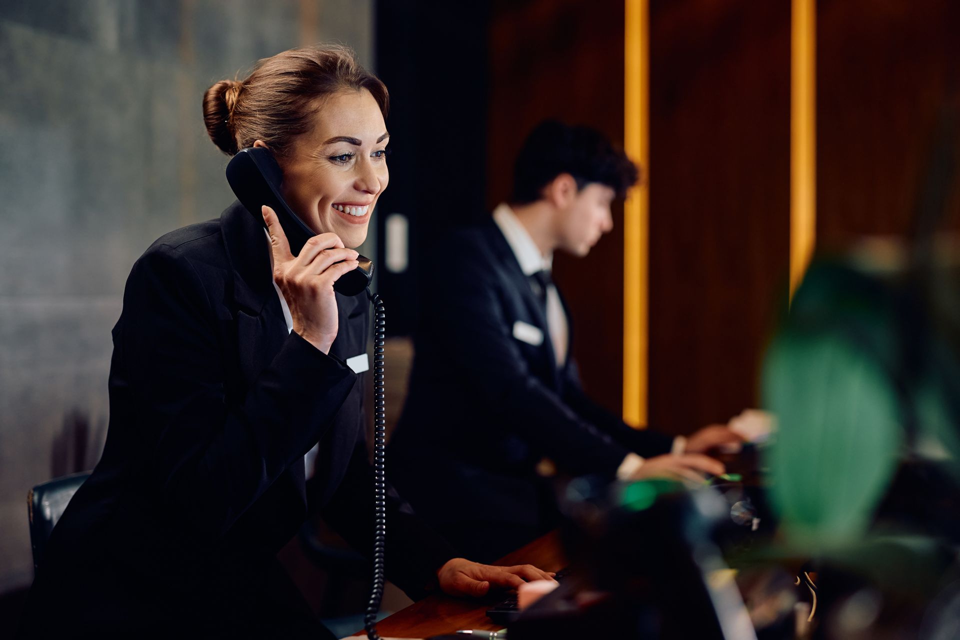 A woman is talking on a phone in a hotel lobby.