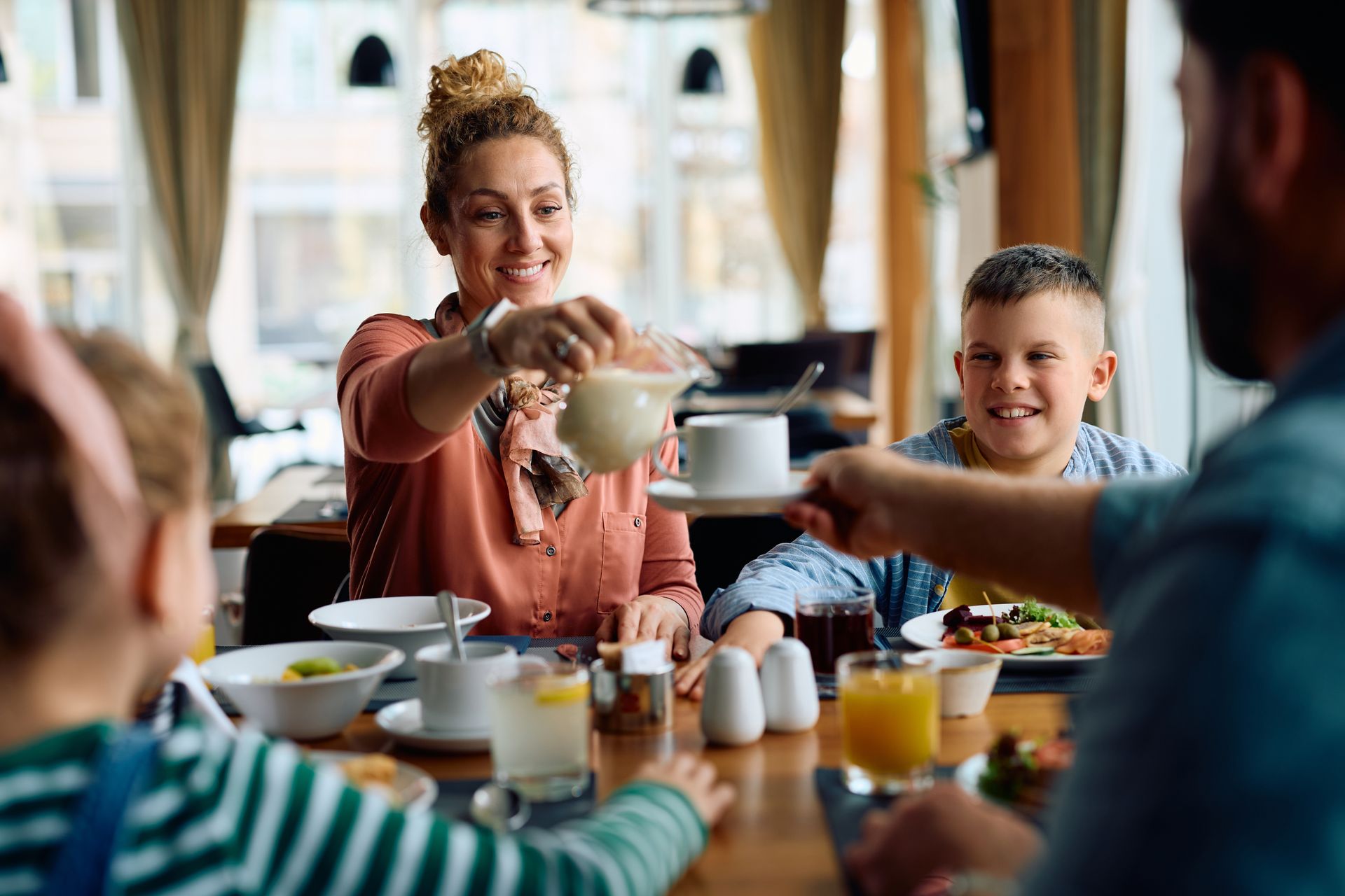 A family is sitting at a table in a restaurant eating breakfast.