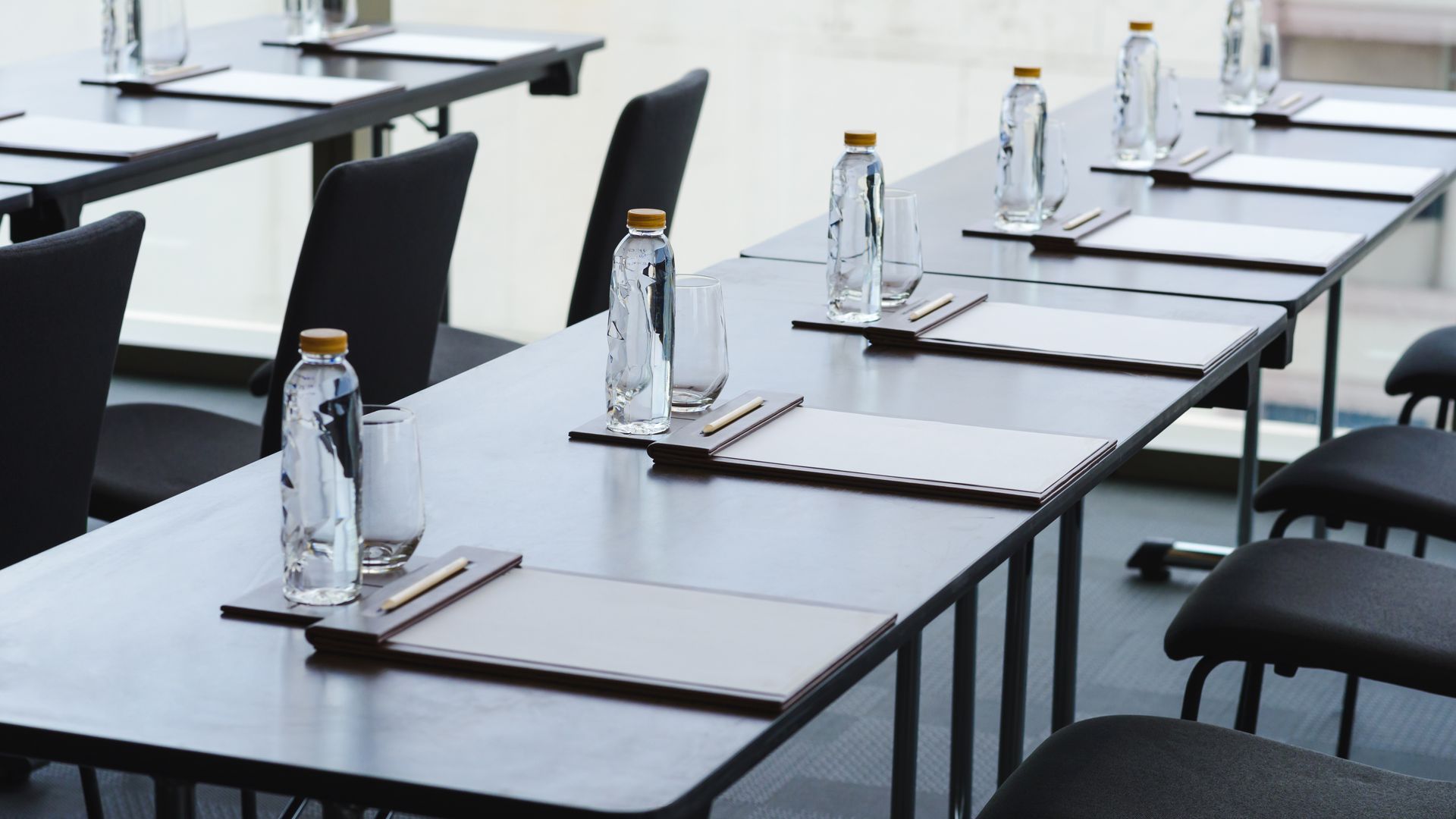 A conference room with tables and chairs set up for a meeting