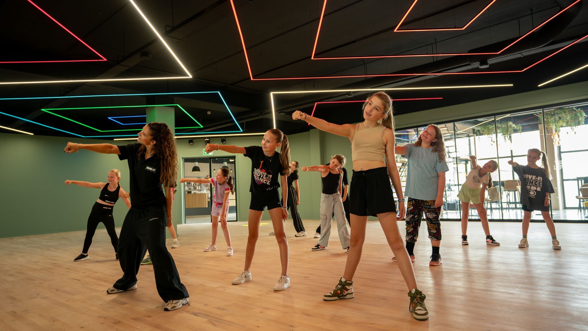 Een groep jonge meisjes danst op een podium.