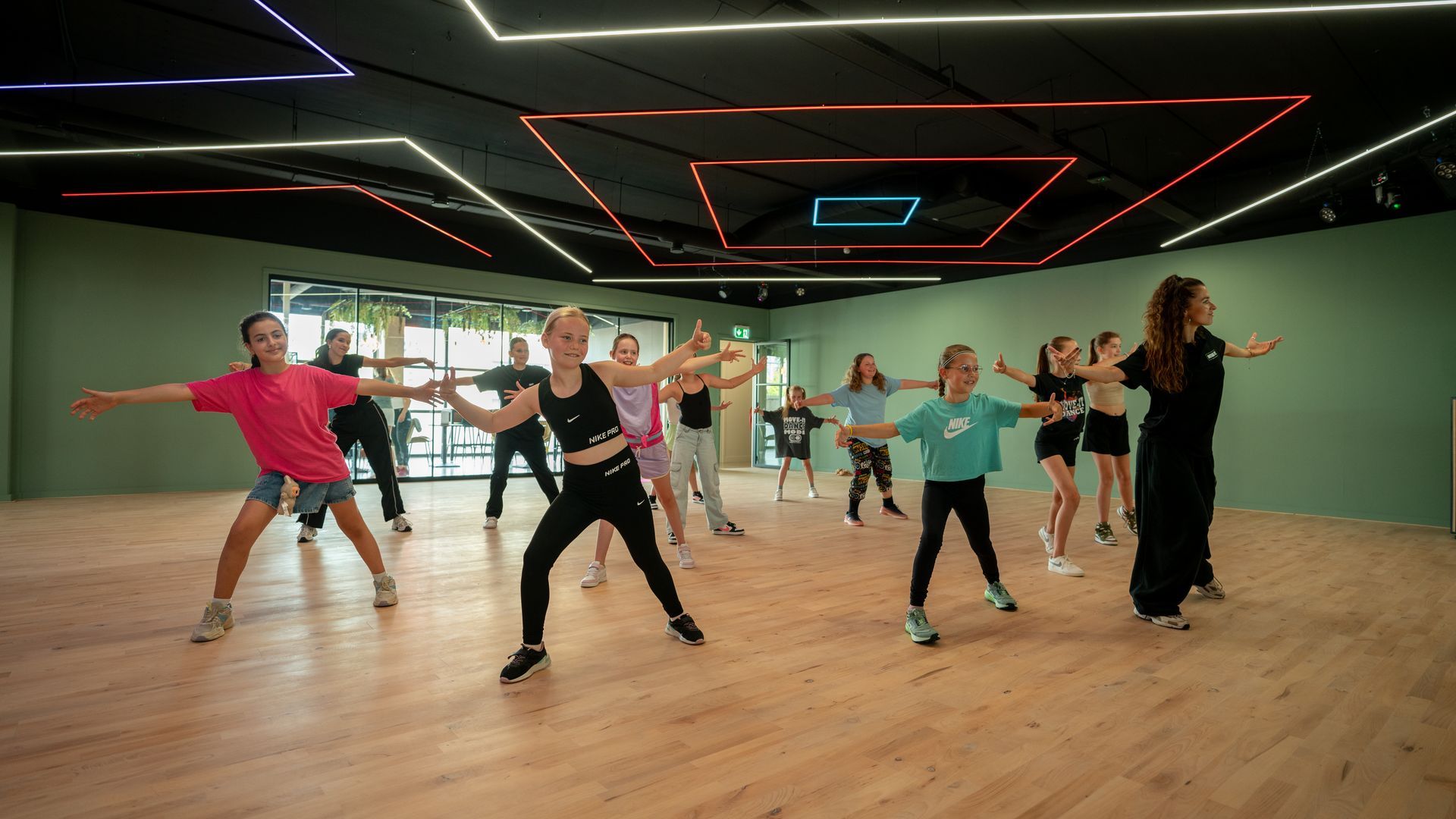 Een groep jongeren danst op een podium.