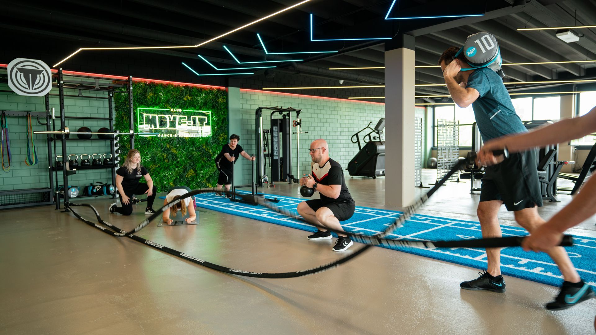 Twee vrouwen zitten op een yogamat in een sportschool.
