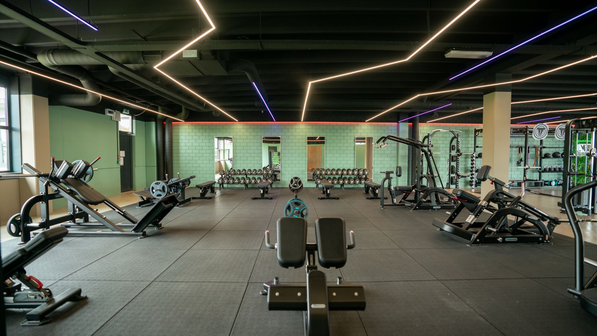 Een persoon tilt een halter op in een sportschool.
