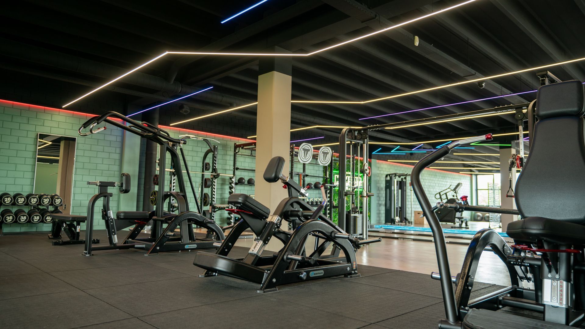 Een sportschool vol met fitnessapparatuur en een bord waarop 'ren' staat.