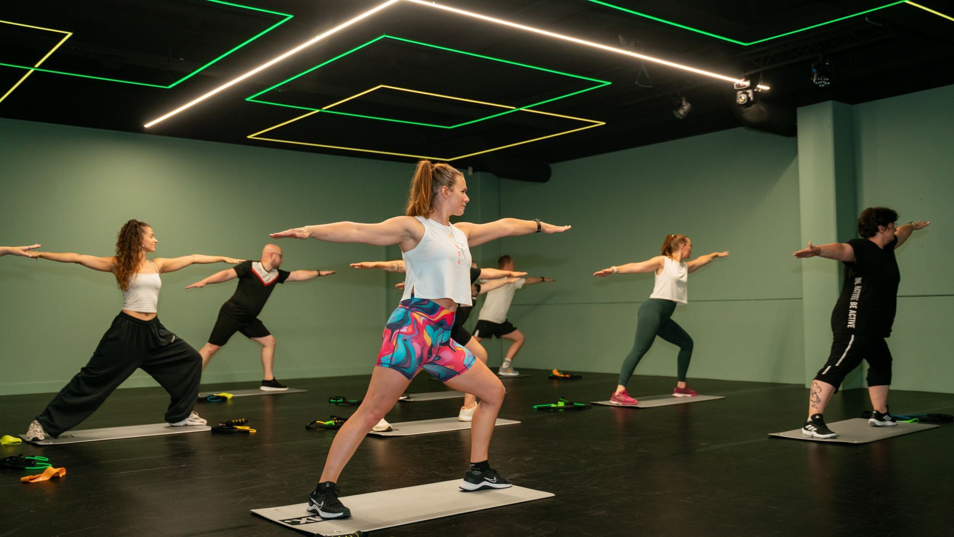 Twee vrouwen zitten op een yogamat in een sportschool.