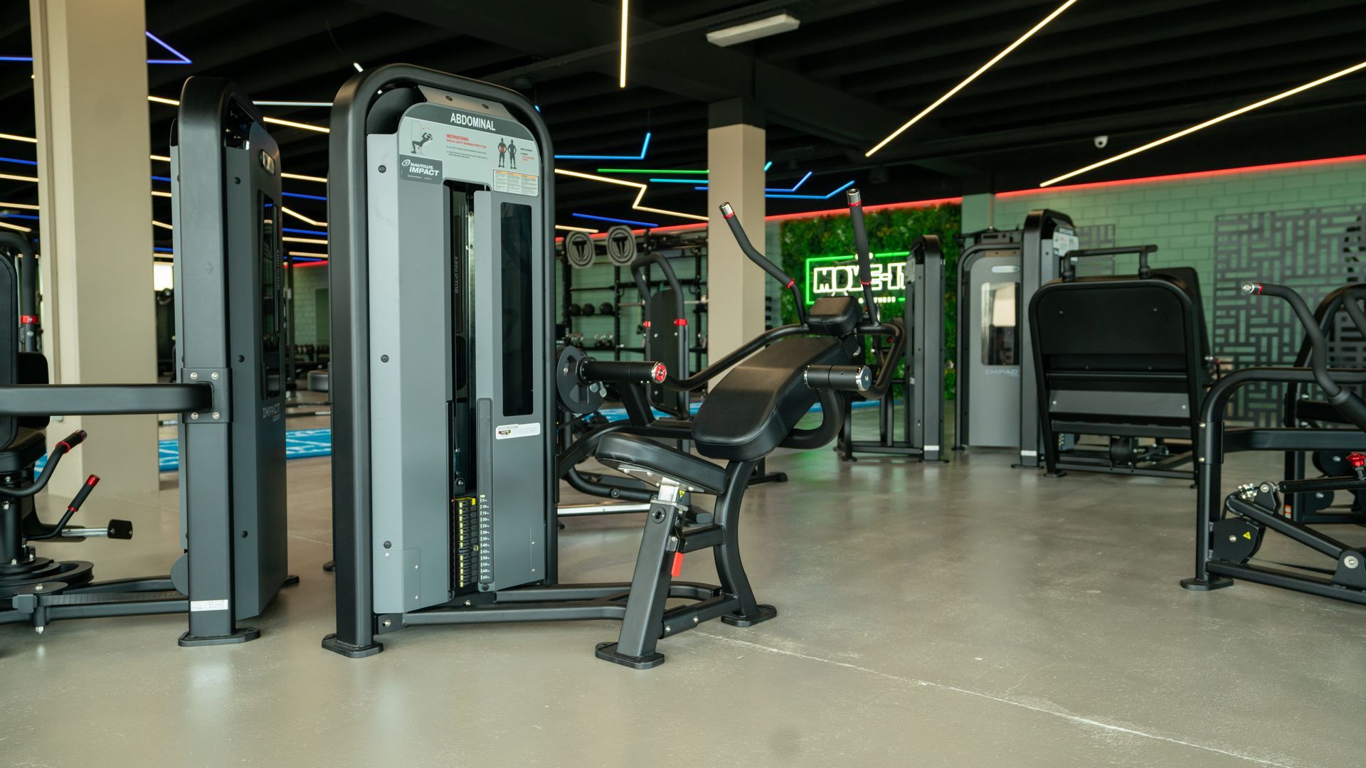 Een sportschool vol met fitnessapparatuur en een bord waarop 'ren' staat.