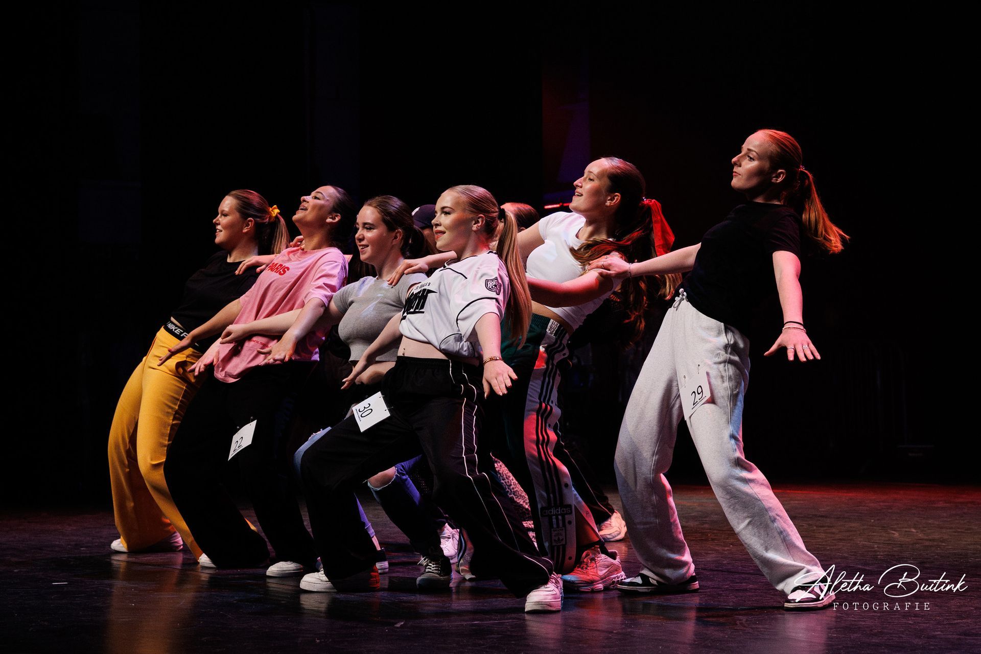 Een groep jonge vrouwen danst samen op een podium.