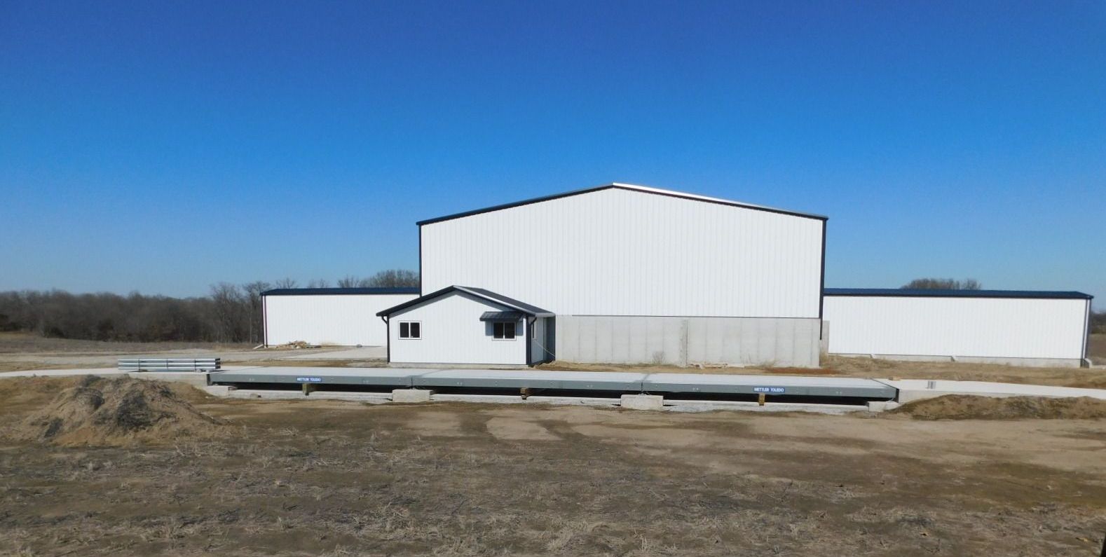 A large white building in the middle of a field