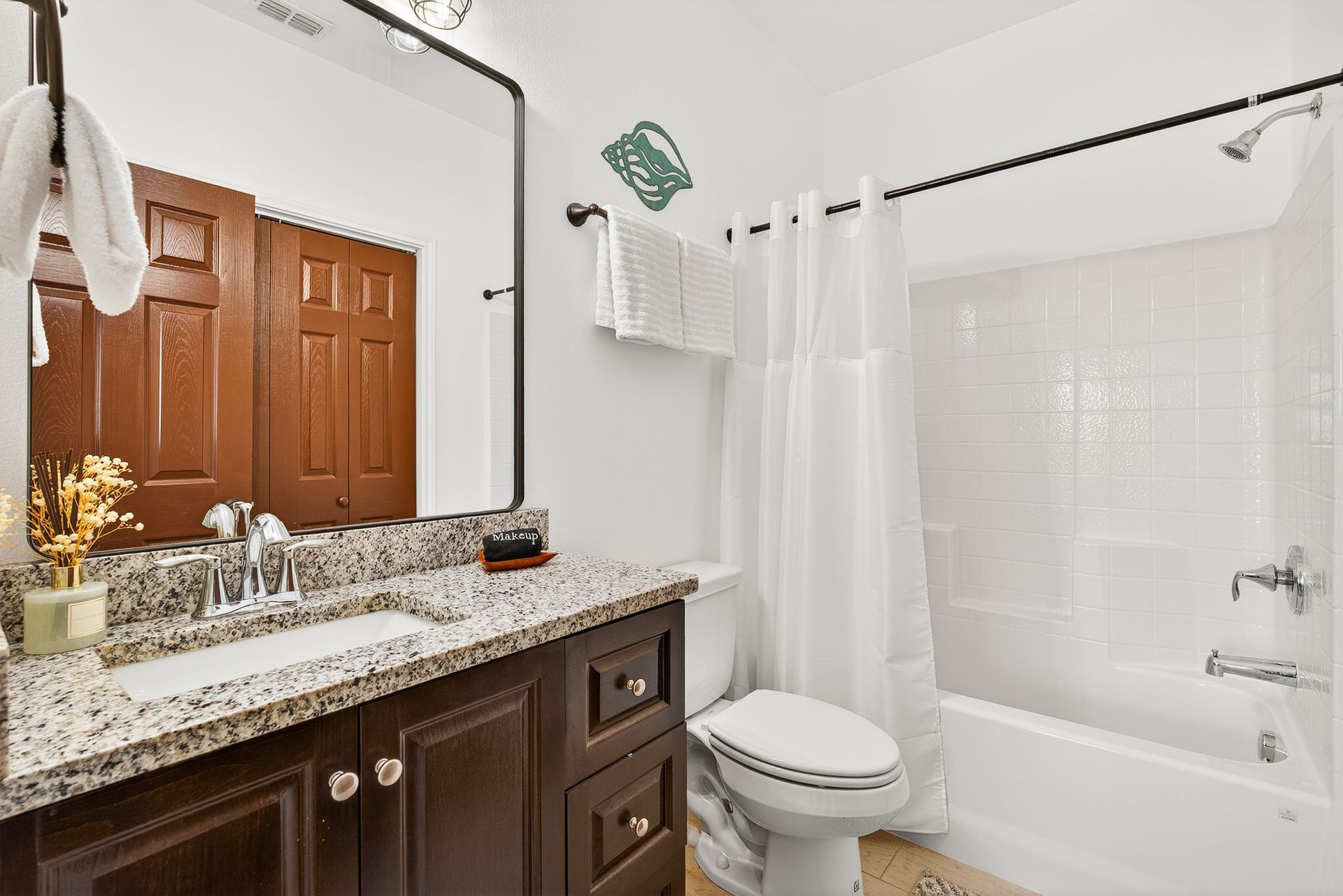 Bright bathroom with vanity and a bathtub with shower