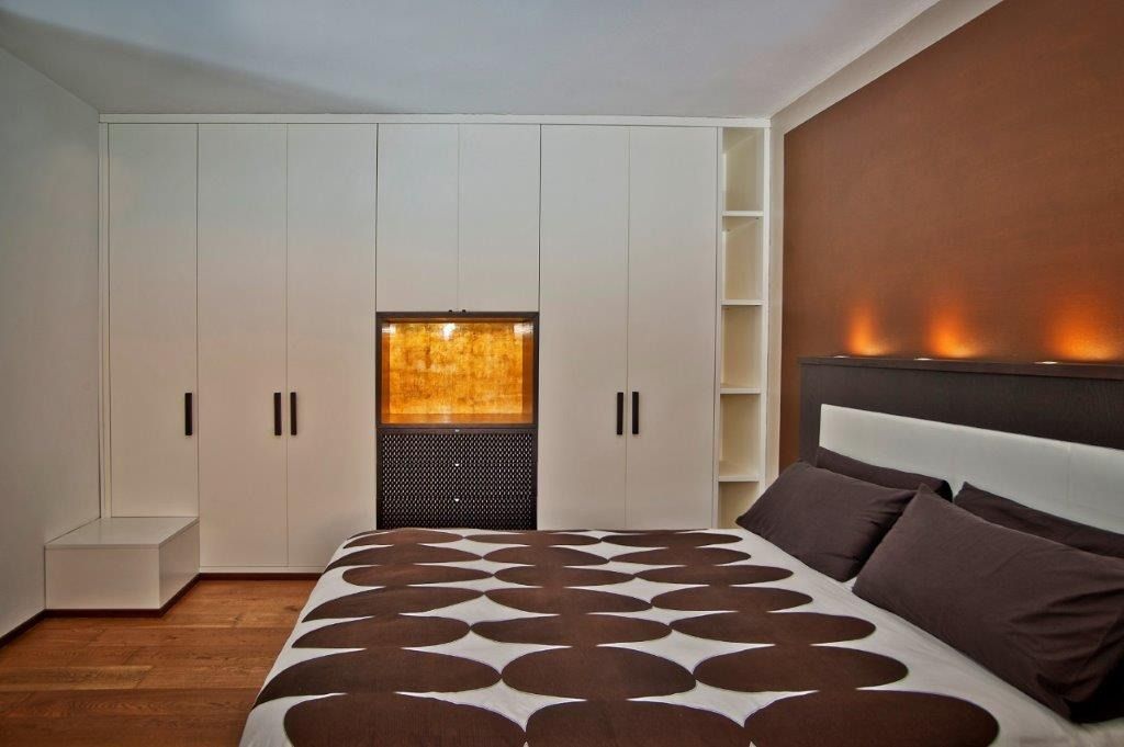 Camera da letto moderna con armadi a muro bianchi.