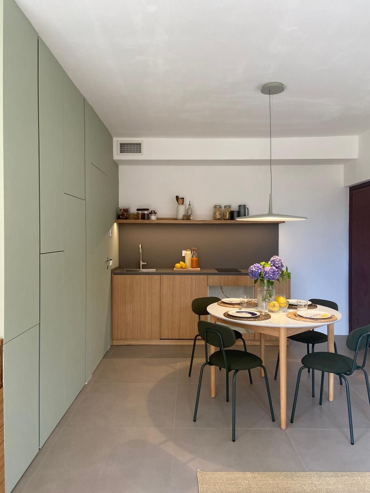 Zona pranzo moderna con mobili verdi, mensole in legno