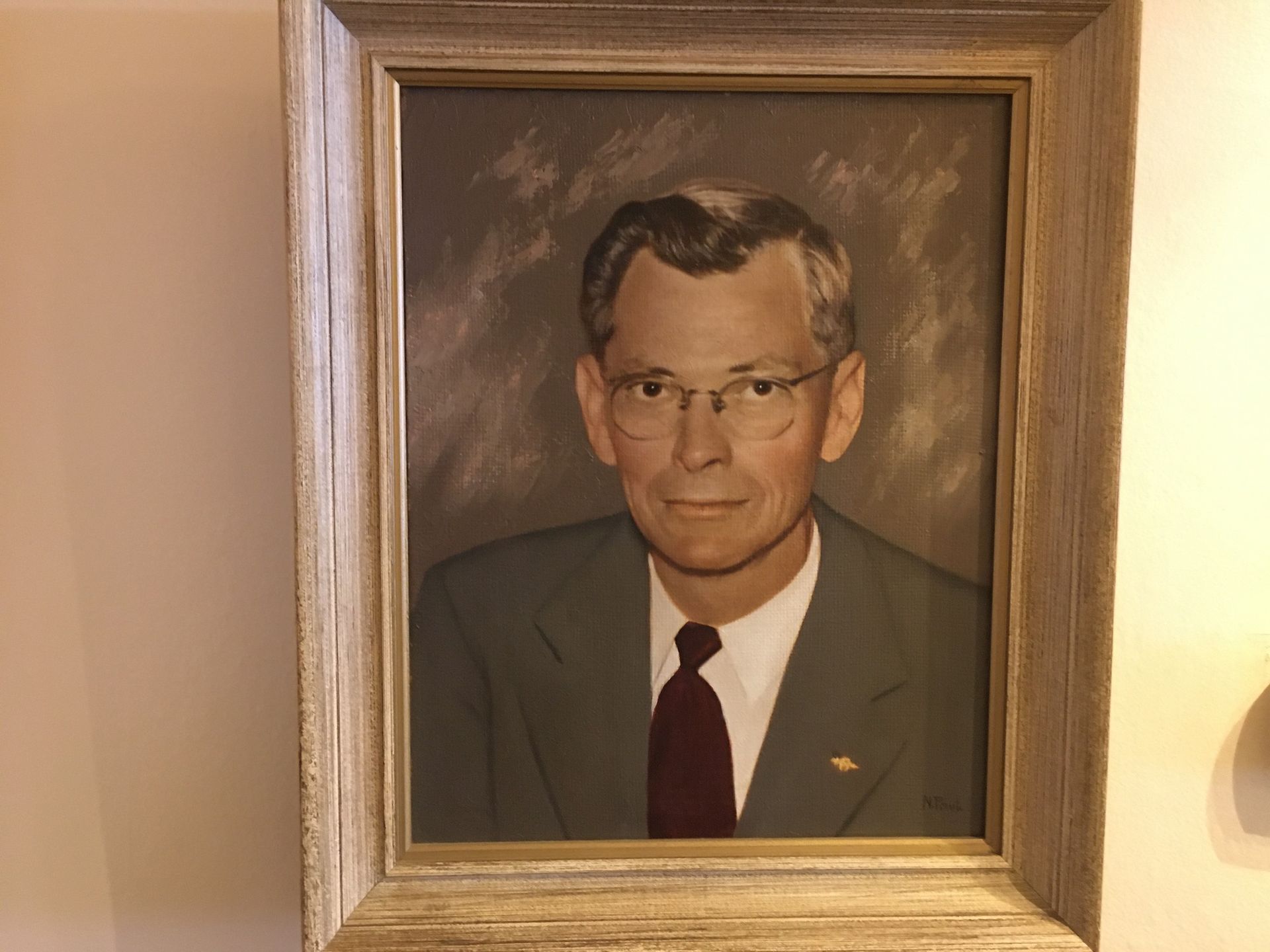 Framed formal portrait of a man in a suit and tie hanging on a wall