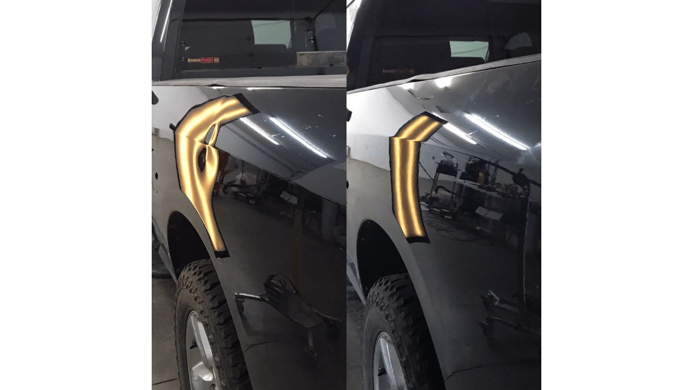 Close-up of a black car with gold trim near the front wheel and hood edge.