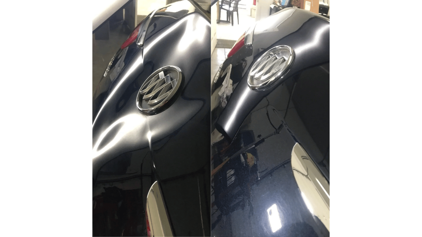 Two black Volkswagen cars parked close together in a garage, showing their front emblems.