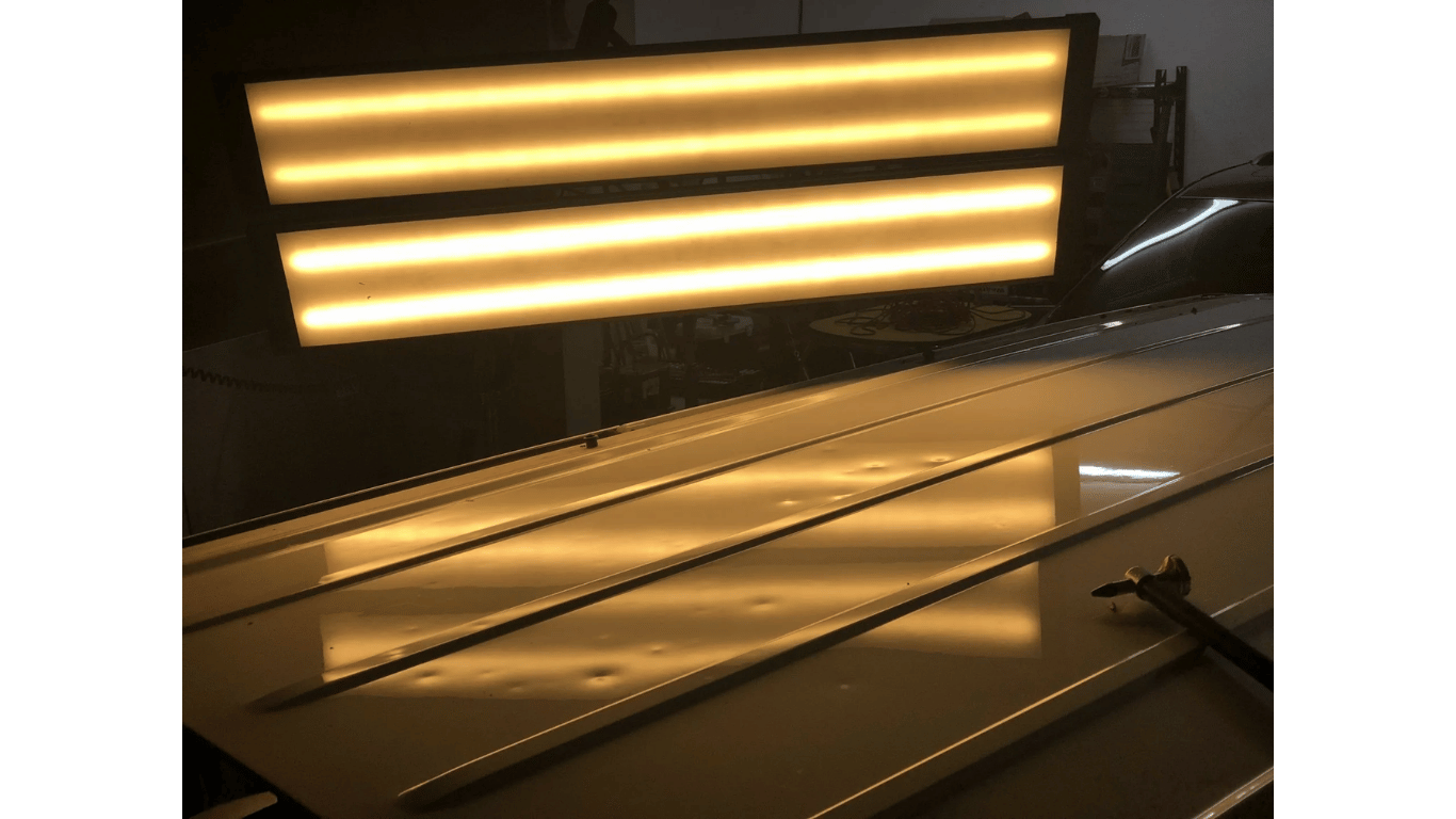 Warm-lit industrial room with glowing horizontal light bars reflecting on a glossy floor