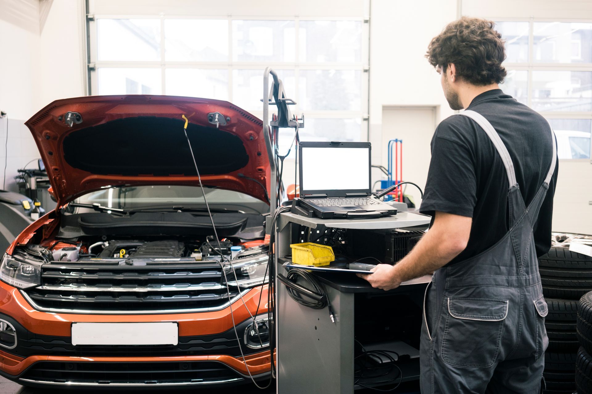 Car mechanic in a workshop using modern diagnostic equipment.