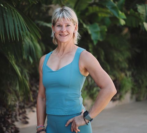 a woman in a pink shirt is smiling for the camera