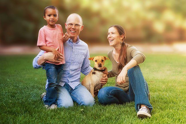 Family and a dog posing for a picture