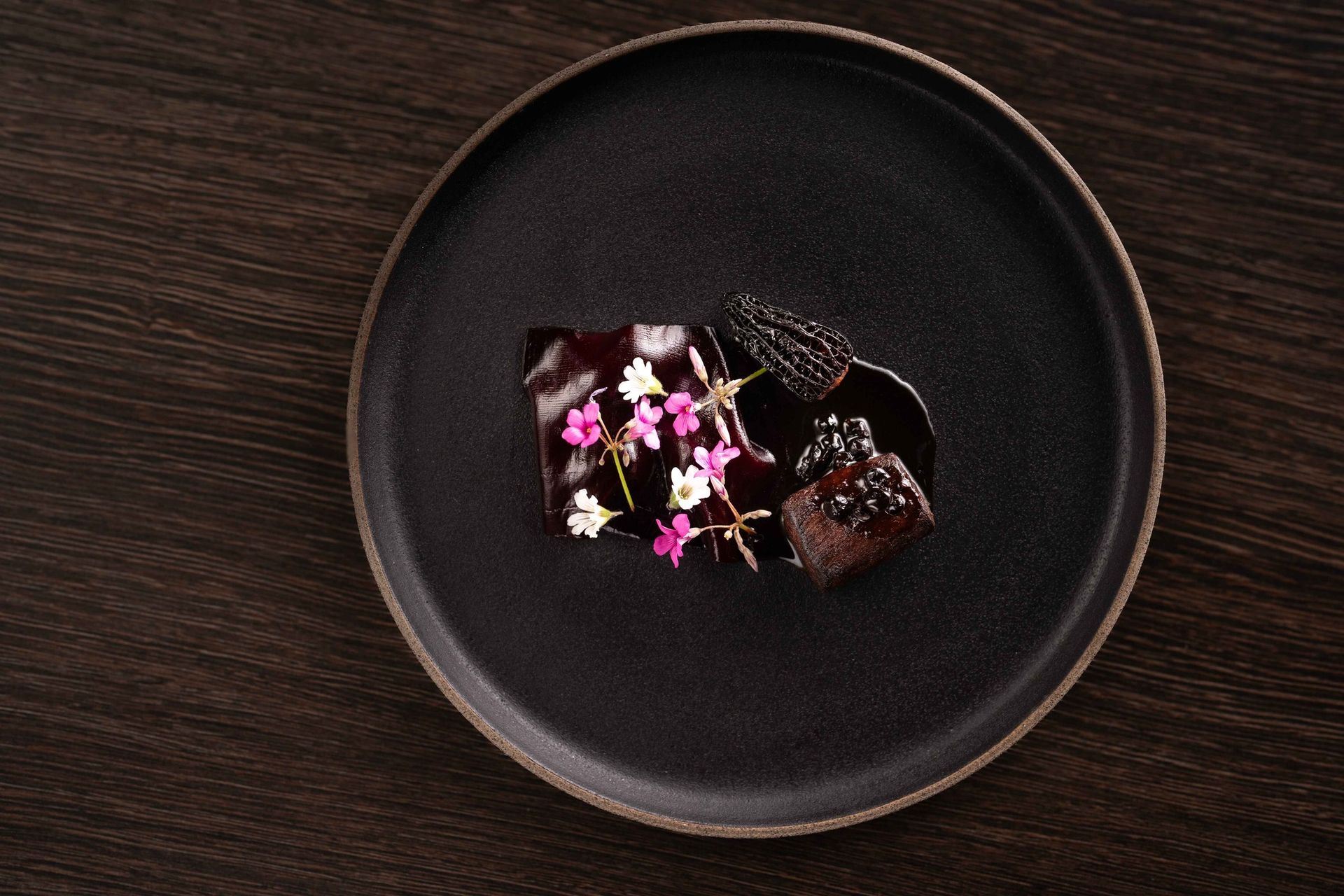 A black plate with a piece of chocolate on it