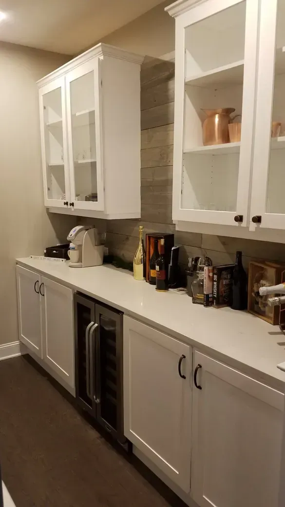 White kitchen with glass-front cabinets, countertop appliances, and a built-in microwave.