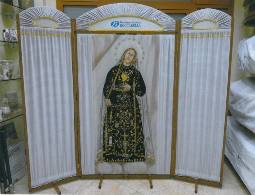Santuario religioso con dipinto centrale di un santo, fiancheggiato da tende bianche drappeggiate. Dettagli dorati e logo blu.