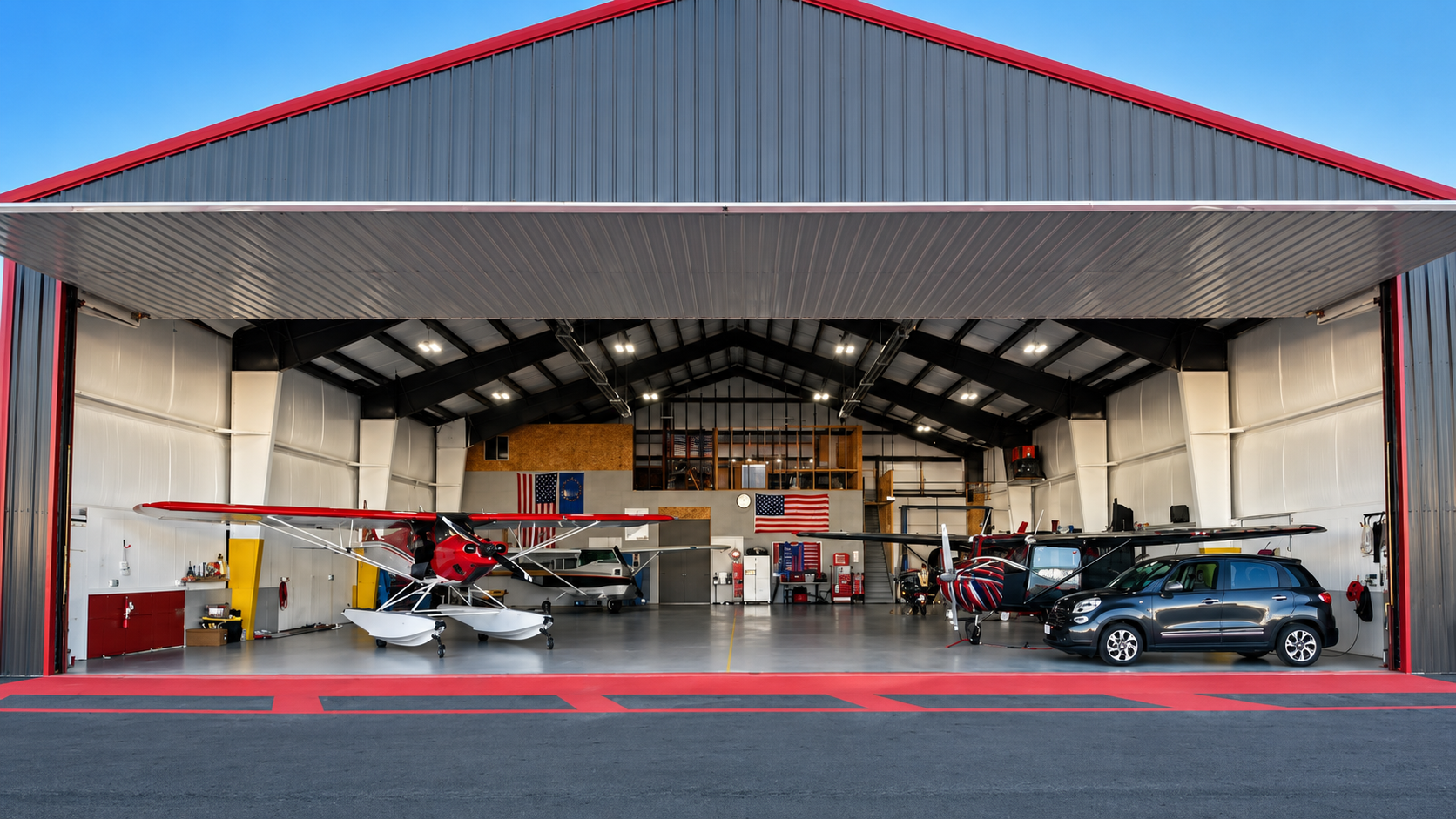 Open airplane hangar with a small plane, workshop gear, and parked cars inside