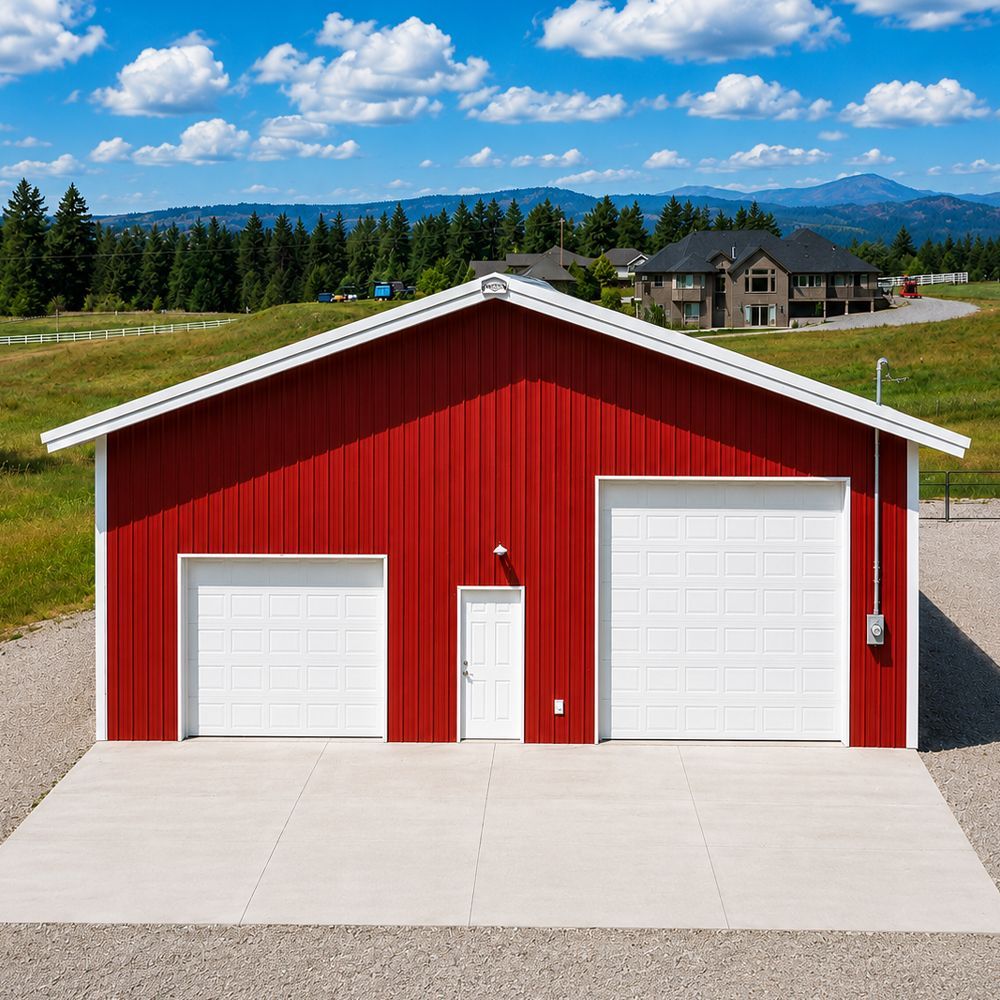 Red barn-style garage with two white doors and a central entry, set on a paved drive with mountains in the background