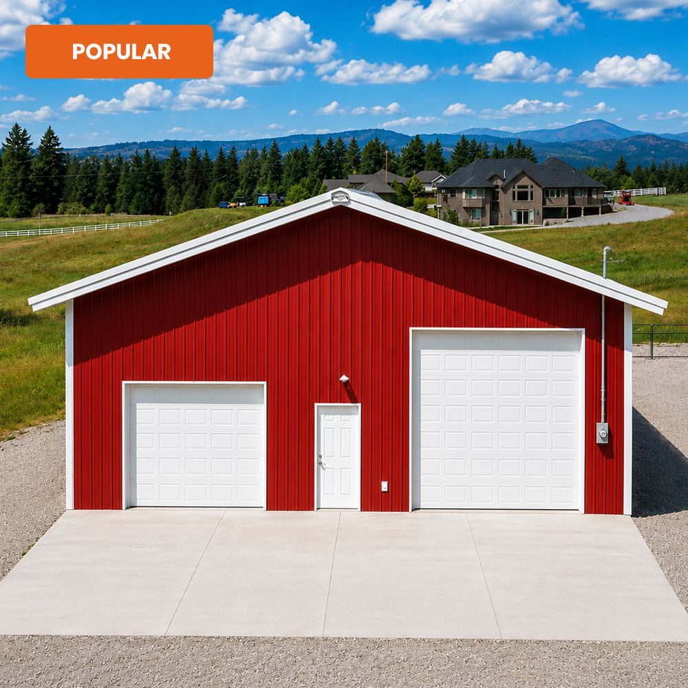Red metal garage with two white doors and a central entry, on a concrete drive in a rural mountain setting.