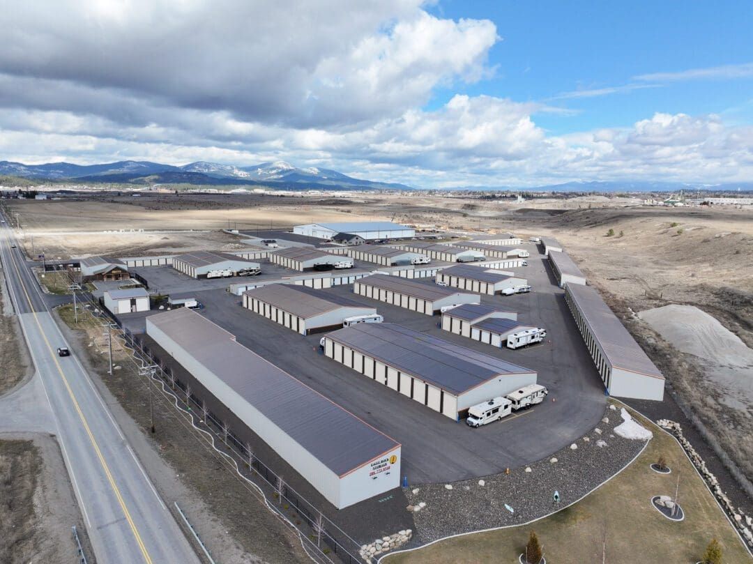 Aerial view of a large industrial warehouse complex in a snowy landscape under a cloudy sky