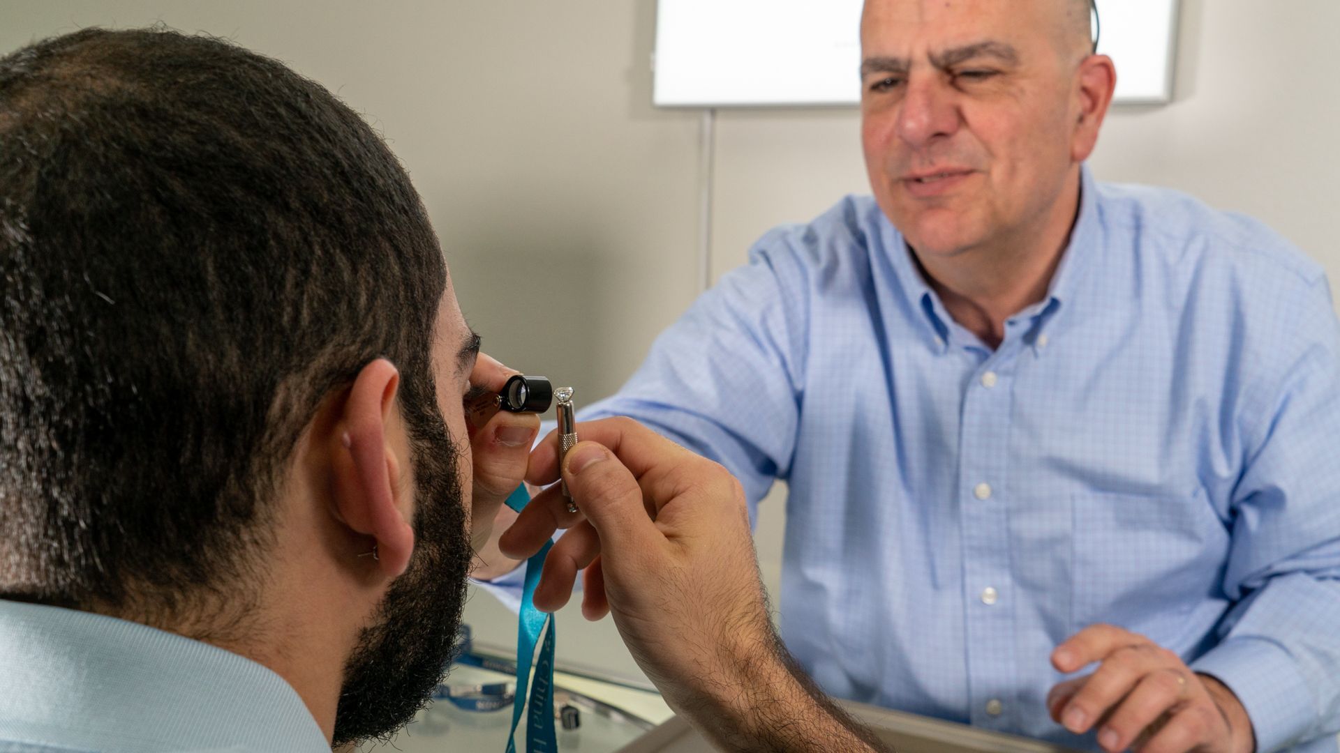 Eye doctor examining a patient’s eye with a handheld instrument in a clinic