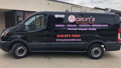 Black Aaron's van with pink lettering parked outside a building