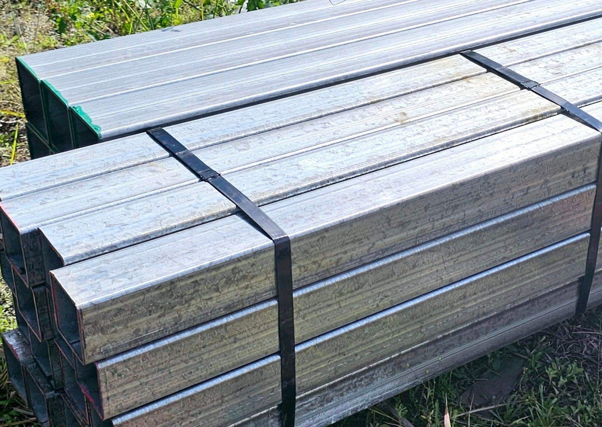 A stack of metal tubes sitting on top of each other in the grass.