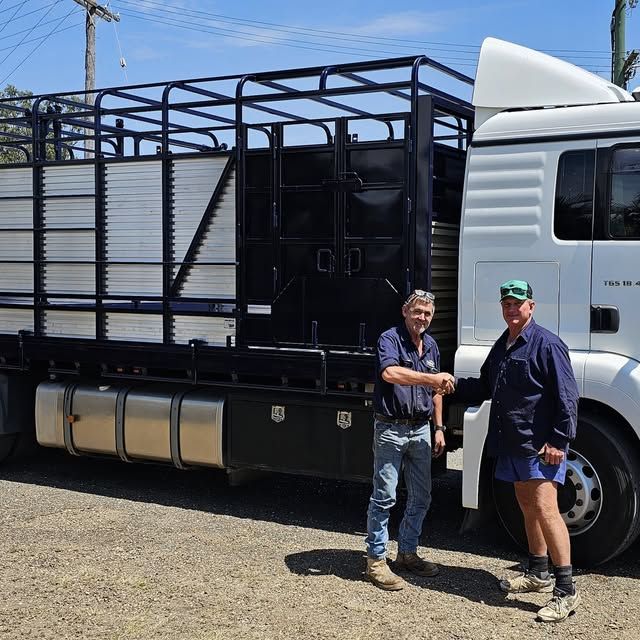 Two men shaking hands in front of a truck that says o.p.