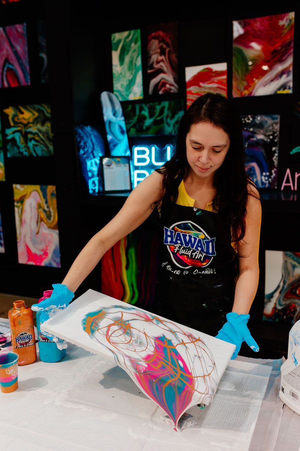 Artist painting a colorful abstract design on a canvas at an art booth