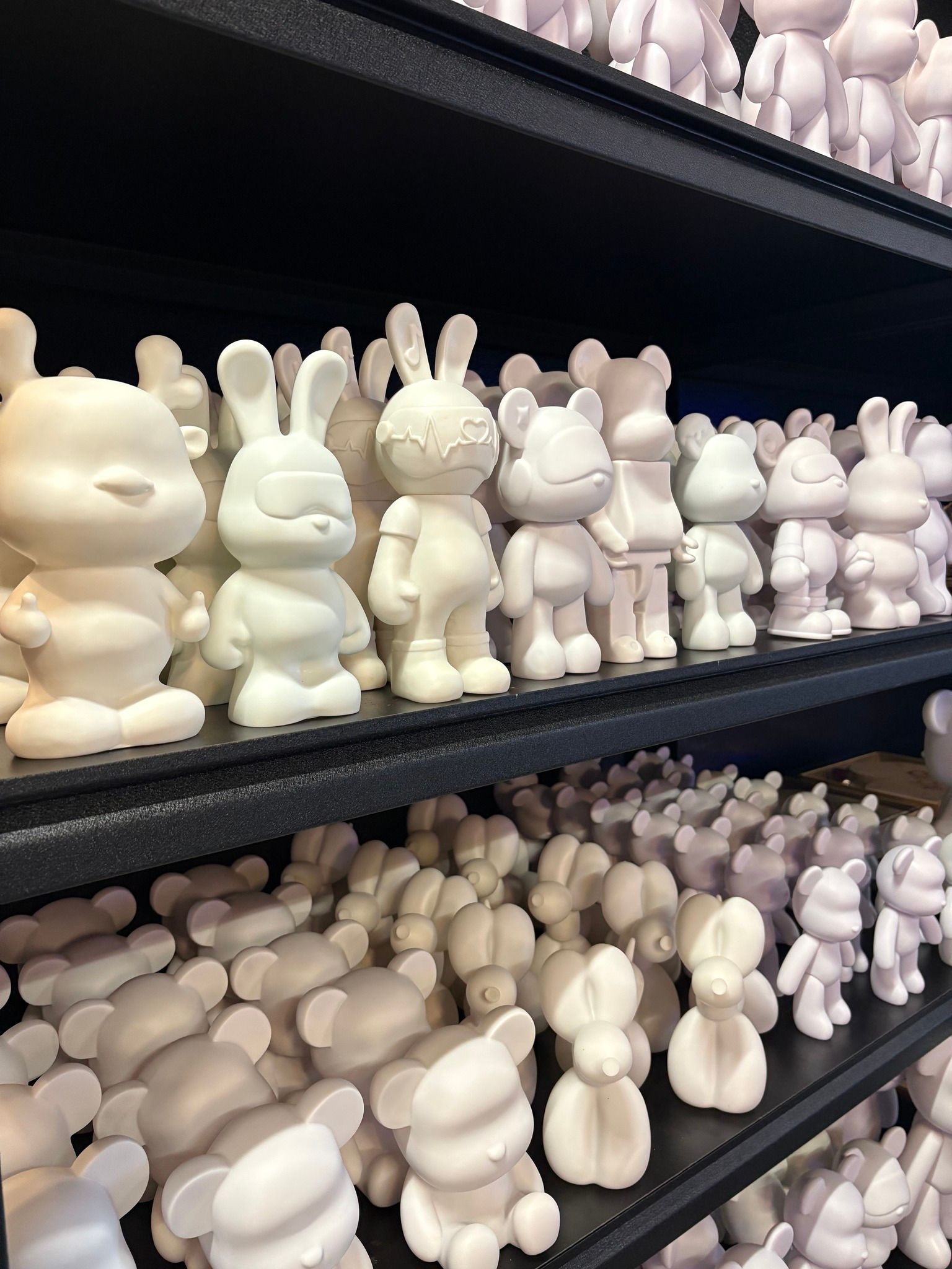 Shelves filled with rows of small white bunny figurines in a store display