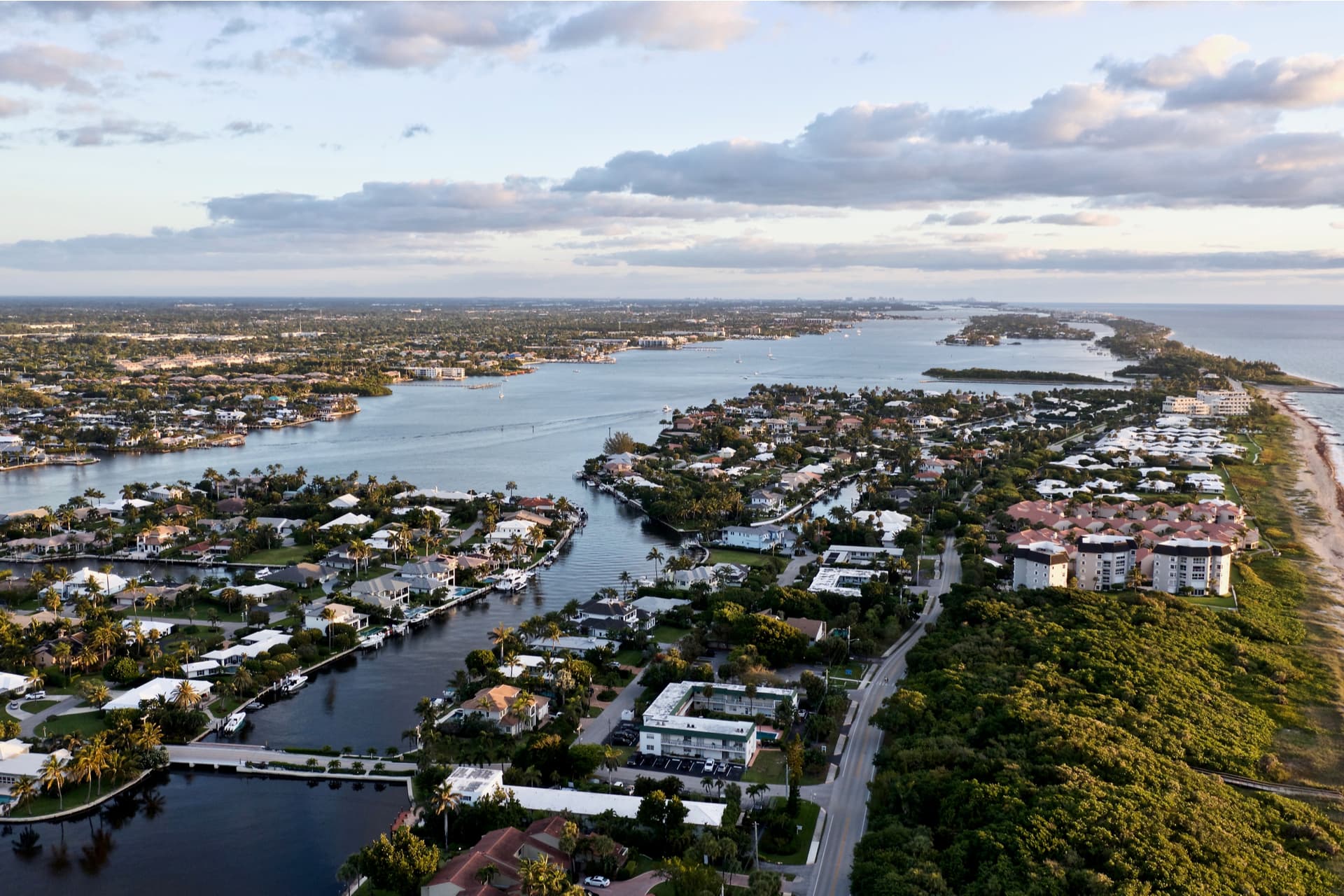 Aerial view of waterfront Boynton Beach homes with backyard pools and tile roofs