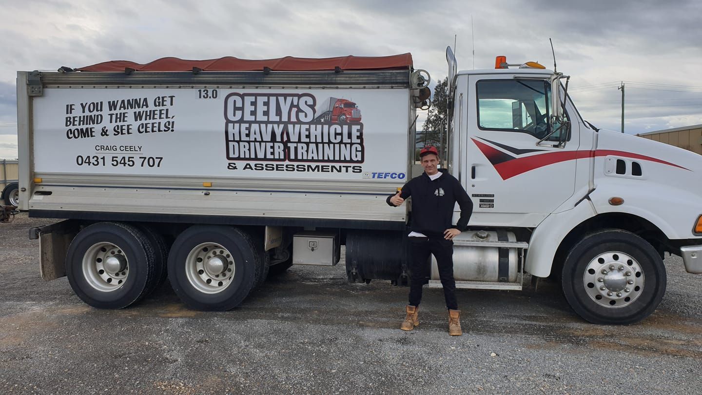 Driver Standing Beside a Learner Truck — Ceely's Heavy Vehicle Driver Training & Assessments In Griffith, NSW
