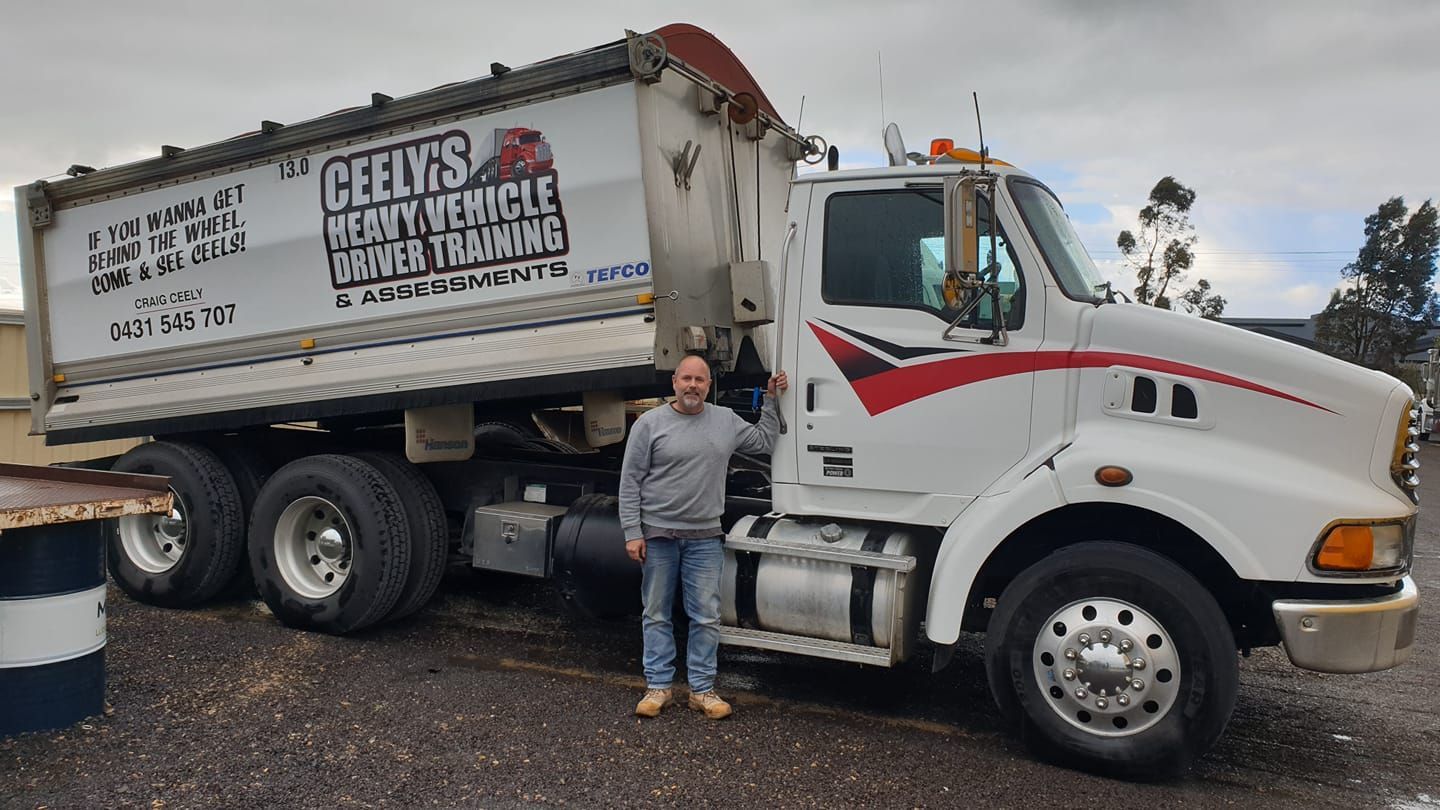 Man Posing With a Training Truck — Ceely's Heavy Vehicle Driver Training & Assessments In Albury, NSW  